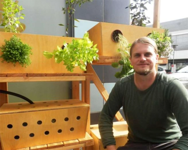Geco-Gardens Bastian vor einem Gemüse- und Kräutergarten